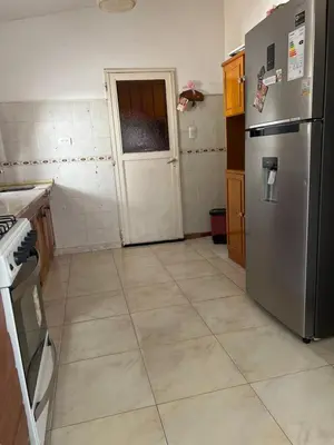 a kitchen with a stainless steel refrigerator and a door at Casa céntrica in Villa Carlos Paz