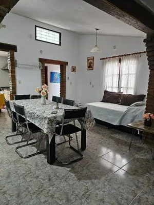 a living room with a table and a bed at CASA PARA 5 CON PILETa in Villa Carlos Paz