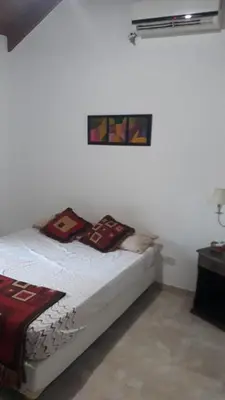 a white room with a bed with pillows on it at Doña issaa in Merlo