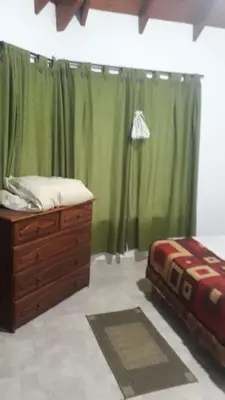 a bedroom with a bed and a dresser in front of a window at Doña issaa in Merlo
