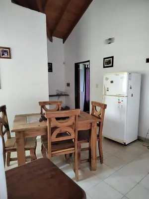 a kitchen with a wooden table and a refrigerator at Doña issaa in Merlo