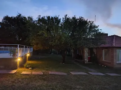 a yard with a fence and a tree at night at Doña issaa in Merlo