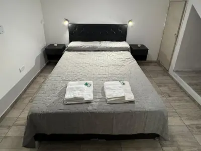 two beds in a room with towels on them at Apart's Sobremonte - Deptos Modernos in Rio Cuarto