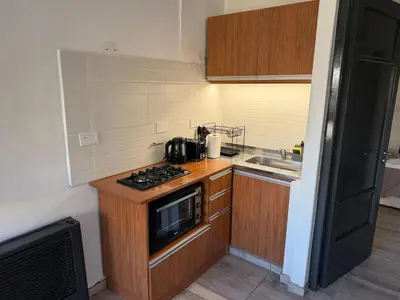 a small kitchen with a stove and a sink at Apart's Sobremonte - Deptos Modernos in Rio Cuarto