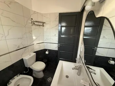 a bathroom with a white toilet and a sink at Apart's Sobremonte - Deptos Modernos in Rio Cuarto