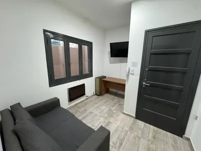 a living room with a couch and a black door at Apart's Sobremonte - Deptos Modernos in Rio Cuarto