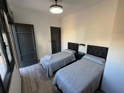 a room with two beds and a light at Apart's Sobremonte - Deptos Modernos in Rio Cuarto