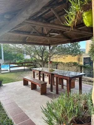 a picnic table and benches under an umbrella at Cabañas EzeNic in Cavalango