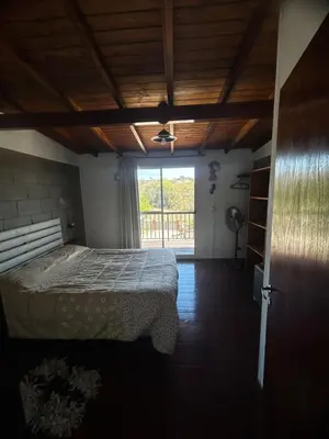 a bedroom with a bed and a large window at Cabañas EzeNic in Cavalango