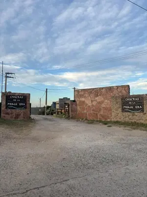 a dirt road with two signs on the side at Cabañas EzeNic in Cavalango