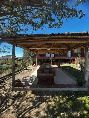 a wooden pavilion with a building in the background at Cabañas EzeNic in Cavalango