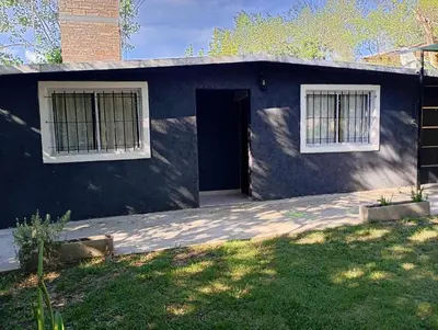 a blue house with a door and two windows at La casa de nona in Villa Carlos Paz