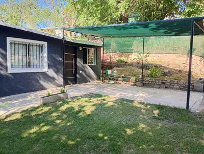 a house with a green canopy in the yard at La casa de nona in Villa Carlos Paz