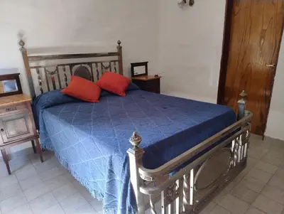 a bedroom with a bed with two red pillows on it at Casa Arroyo in Villa Carlos Paz