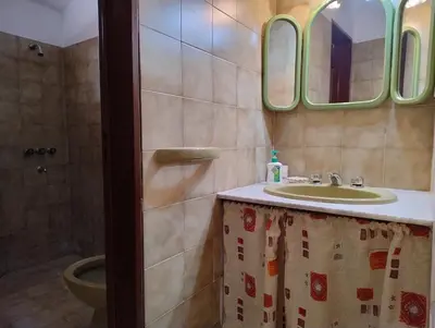 a bathroom with a sink and a mirror and a toilet at Casa Arroyo in Villa Carlos Paz