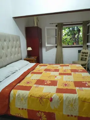a bedroom with a bed with a colorful quilt on it at Hosteria Champaqui in Los Hornillos