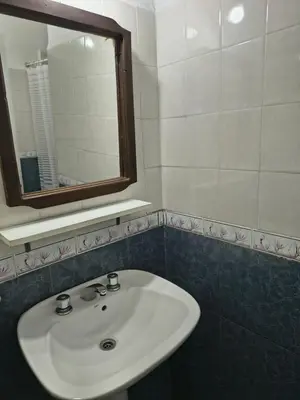 a bathroom with a white sink and a mirror at Hosteria Champaqui in Los Hornillos