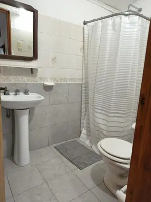 a bathroom with a toilet and a sink and a shower at Hosteria Champaqui in Los Hornillos