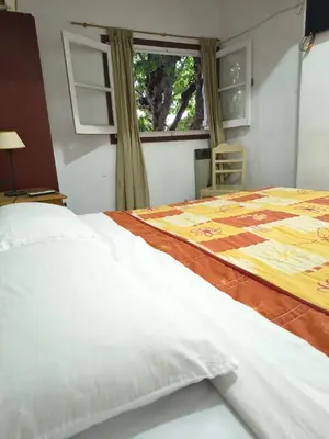 a bedroom with a large white bed with a window at Hosteria Champaqui in Los Hornillos