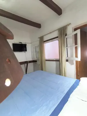 a bedroom with a large bed and a window at Hosteria Champaqui in Los Hornillos