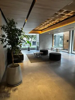 a lobby with a potted tree in a building at Hermoso Departamento en zona Quality Espacio, Hospital Privado Universitario de Córdoba in Cordoba