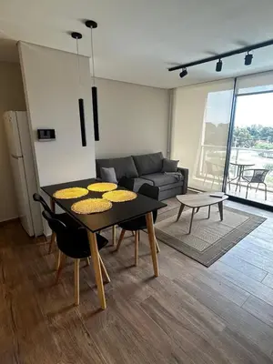 a living room with a table and a couch at Hermoso Departamento en zona Quality Espacio, Hospital Privado Universitario de Córdoba in Cordoba
