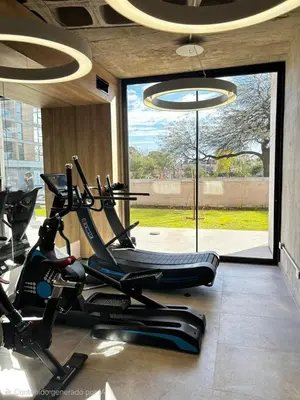 a gym with a bike in a room with a window at Hermoso Departamento en zona Quality Espacio, Hospital Privado Universitario de Córdoba in Cordoba