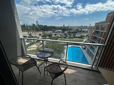 a balcony with chairs and a table and a pool at Hermoso Departamento en zona Quality Espacio, Hospital Privado Universitario de Córdoba in Cordoba