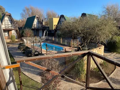 a view of a house with a fence and a pool at Alpinas del Valle in Santa Rosa de Calamuchita