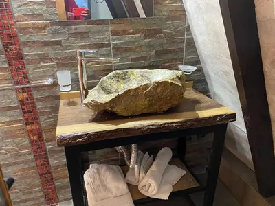 a large rock sitting on a table next to a wall at Alpinas del Valle in Santa Rosa de Calamuchita