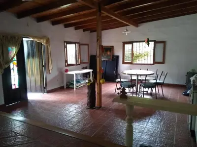 a living room with a table and chairs and windows at Casa colibrí in Tanti