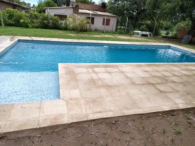 a swimming pool in a yard next to a house at Cabaña papáviejo in Villa de Las Rosas