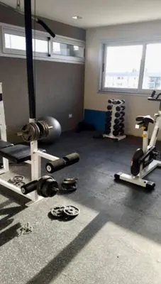 a gym with several exercise equipment in a room at City Paz in Villa Carlos Paz