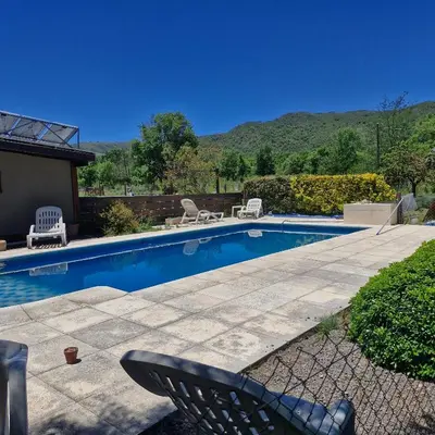 a swimming pool with two chairs and a table and a chair at die lavendel chalet in Villa General Belgrano