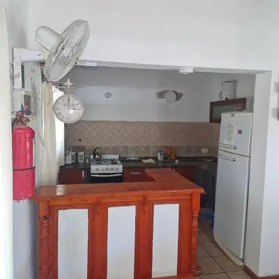 a small kitchen with a stove and a refrigerator at die lavendel chalet in Villa General Belgrano