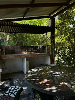 a patio with a table and a bench under a roof at PurinkiWasi - La casa de todos in Los Reartes