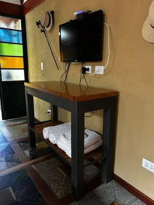 a small table with a television on a wall at PurinkiWasi - La casa de todos in Los Reartes
