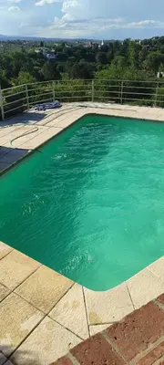 a large swimming pool with green water in it at Casa Villa Carlos Paz in Villa Carlos Paz