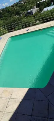 a large swimming pool with green water in a house at Casa Villa Carlos Paz in Villa Carlos Paz