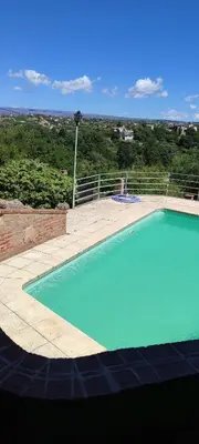 a large blue swimming pool with a view of the countryside at Casa Villa Carlos Paz in Villa Carlos Paz