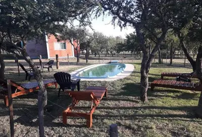 a swimming pool with tables and benches in a park at Arcoiris de Cortaderas in Cortaderas
