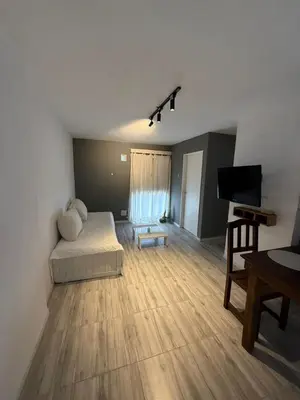 a living room with a bed and a flat screen tv at Junior Towers Modern Apartment in Cordoba