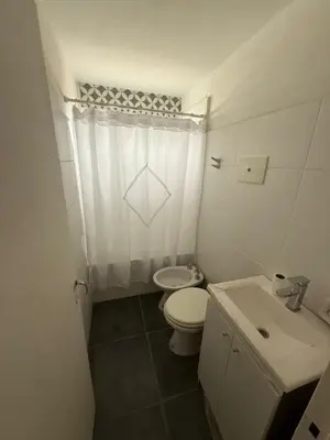 a white bathroom with a toilet and a sink at Junior Towers Modern Apartment in Cordoba