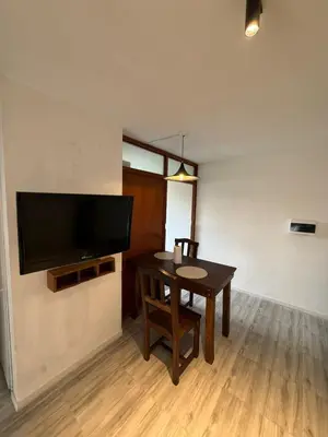 a dining room with a table and a flat screen tv at Junior Towers Modern Apartment in Cordoba