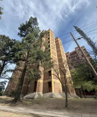 a tall building with trees in front of it at Junior Towers Modern Apartment in Cordoba