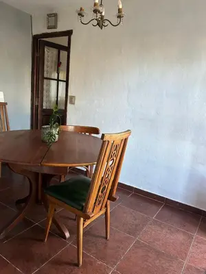 a dining room table and chairs with a table and a chandelier at Casa Puna in Alta Gracia
