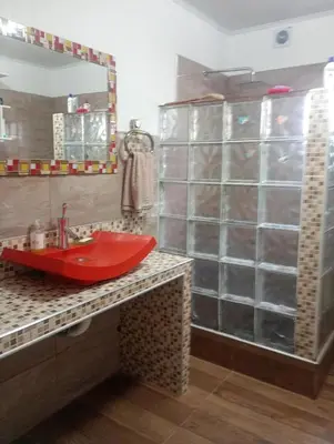 a bathroom with a red sink and a shower at La Soñada in Villa Parque Siquiman