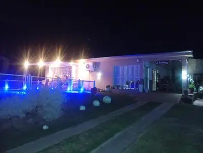 a house lit up at night with blue lights at La Soñada in Villa Parque Siquiman