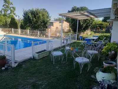 a patio with chairs and a table next to a pool at La Soñada in Villa Parque Siquiman