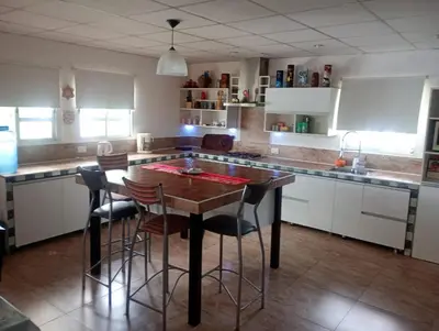 a kitchen with a wooden table and some chairs at La Soñada in Villa Parque Siquiman